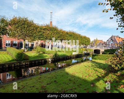 Häuser mit Gärten am Wasser am Kanal Eegracht in der Stadt IJlst, Friesland, Niederlande Stockfoto