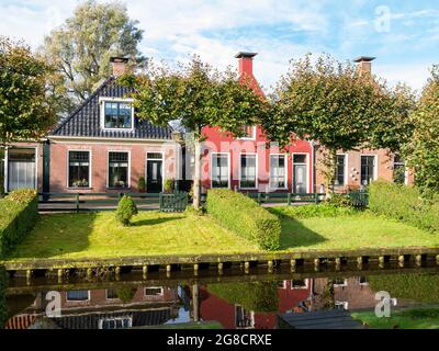 Drei Häuser mit Gärten am Wasser am Eegracht-Kanal in der Stadt IJlst, Friesland, Niederlande Stockfoto