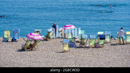 Bier, East Devon; 19. Juli 2021. Wetter in Großbritannien: Urlauber genießen den herrlichen Sonnenschein und entspannen sich am Strand und kühlen sich im blauen Meer im hübschen Fischer- und Küstendorf Beer, East Devon ab. Kredit: Celia McMahon/Alamy Live Nachrichten Stockfoto