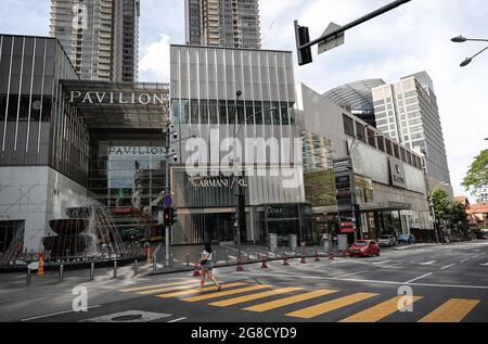 Kuala Lumpur, Malaysia. Juli 2021. Eine Frau überquert eine leere Straße in der Innenstadt von Kuala Lumpur, die aufgrund eines Anstiegs der COVID-19-Infektionen gesperrt ist. (Foto von Wong Fok Loy/SOPA Images/Sipa USA) Quelle: SIPA USA/Alamy Live News Stockfoto