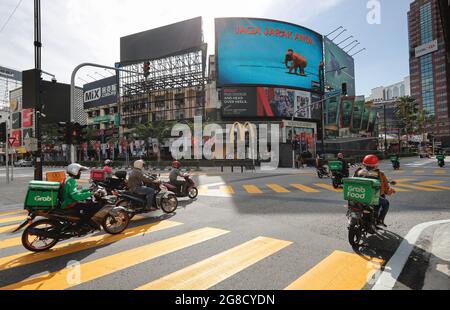 Kuala Lumpur, Malaysia. Juli 2021. Lebensmittellieferer fahren entlang einer leeren Straße in der Innenstadt von Kuala Lumpur inmitten von Sperrbeschränkungen aufgrund eines Anstiegs an COVID-19-Infektionen. (Foto von Wong Fok Loy/SOPA Images/Sipa USA) Quelle: SIPA USA/Alamy Live News Stockfoto