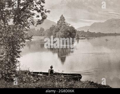 Eine Ansicht aus dem späten 19. Jahrhundert von einer jungen Frau auf einem Ruderboot in der Nähe von Swan Island am Loch Lomond im Trossachs National Park, Argyll & Bute, Schottland. Stockfoto