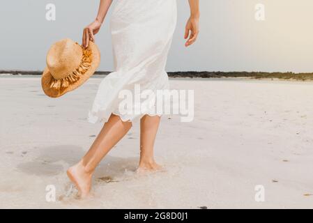 Frau in Kleid zu Fuß am Sandstrand Stockfoto