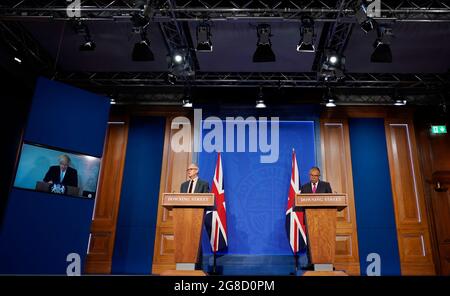 (Von links nach rechts) Premierminister Boris Johnson erscheint auf einem Bildschirm von Chequers, dem Landhaus des amtierenden britischen Premierministers, wo er sich selbst isoliert, der wissenschaftliche Chefberater Sir Patrick Vallance und der stellvertretende leitende medizinische Offizier für England Professor Jonathan Van Tam, während einer Medienbesprechung in der Downing Street, London, über das Coronavirus (Covid-19). Bilddatum: Montag, 19. Juli 2021. Stockfoto