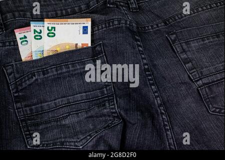 10 20 50 Euro, die aus der Tasche schwarzer Jeans kommen Stockfoto