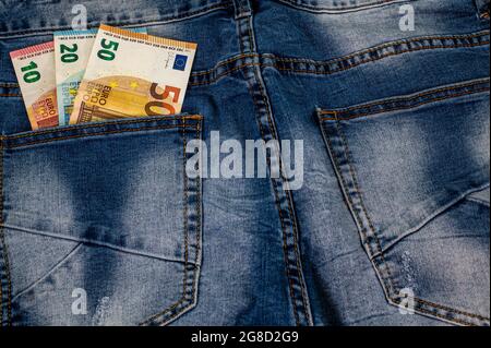 10 20 50 Euro, die aus der Tasche der blauen Jeans kommen Stockfoto