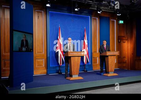 (Von links nach rechts) Premierminister Boris Johnson erscheint auf einem Bildschirm von Chequers, dem Landhaus des amtierenden britischen Premierministers, wo er sich selbst isoliert, der wissenschaftliche Chefberater Sir Patrick Vallance und der stellvertretende leitende medizinische Offizier für England Professor Jonathan Van Tam, während einer Medienbesprechung in der Downing Street, London, über das Coronavirus (Covid-19). Bilddatum: Montag, 19. Juli 2021. Stockfoto