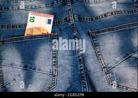 10 Euro, die aus der Tasche der blauen Jeans kommen Stockfoto