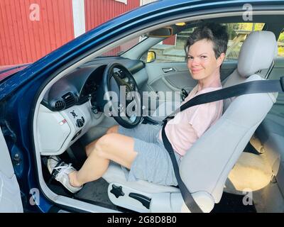 Armlose Frau fährt ein speziell angepasstes Mercedes Benz Coupé mit Fußlenkung Stockfoto