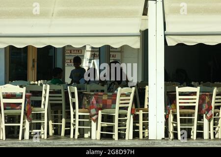 Insel Naxos, Griechenland. Altstadt. Nahaufnahme eines Cafés am Hafen mit einer schattigen Terrasse. Landschaftsaufnahme. Stockfoto