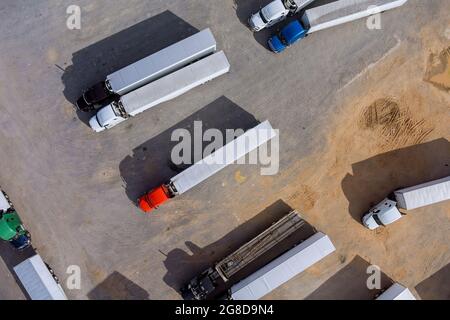 Rastplatz mit verschiedenen Arten von Lastwagen auf einem überfüllten Parkplatz in der Nähe der Autobahn Stockfoto