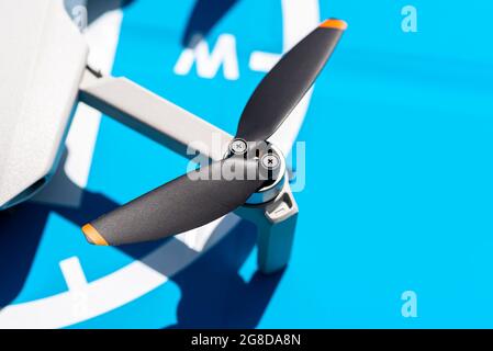 Nahaufnahme der komplexen Propeller und des bürstenlosen Motors einer Drohne vor dem Hintergrund eines blauen Landeplatts. Stockfoto