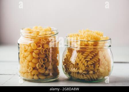 Zwei Arten von italienischen Vollkornnudeln in Gläsern Stockfoto