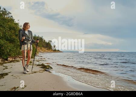 Weibliche Bummel am Sandstrand in der Nähe des Sees Stockfoto