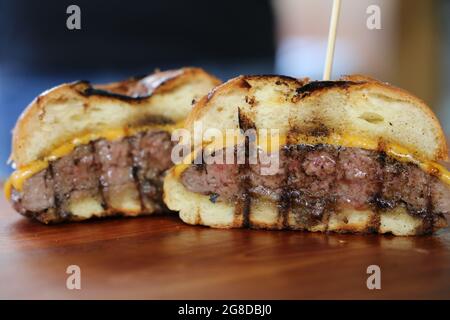 Käseburger und Brot im Grill gemacht. Seitenansicht. Nahaufnahme. Auf Holzhintergrund. Stockfoto