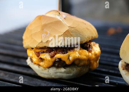 Käseburger, Tomaten und Brot im Grill gemacht. Seitenansicht. Nahaufnahme. Stockfoto