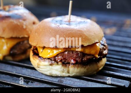 Käseburger, Tomaten und Brot im Grill gemacht. Seitenansicht. Nahaufnahme. Stockfoto