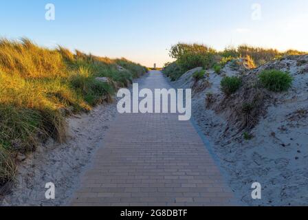 Sanddünen-Wanderweg entlang der Nordseeküste mit Wolkenkratzer in der Ferne, Oostende (Ostende), Belgien. Stockfoto