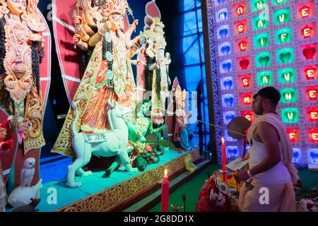 Howrah, Westbengalen, Indien - 5. Oktober 2019 : Hindu-Priester, der Ritual durchführt, indem er Asura mit einem Stock und einem heiligen grünen Blatt an Establis anfasst Stockfoto