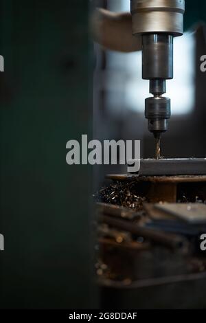 Nahaufnahme von professionellen Mitarbeitern, die Löcher in Metallteile auf der Drehbank bohren. Konzept der metallverarbeitenden Industrie. Stockfoto