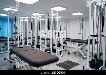 Massageliege in Nahaufnahme im Erholungszentrum. Innenraum des Physiotherapie-Schranks. Reha-Kraftmaschinen Stockfoto