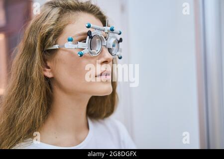 Schöne junge Frau mit optischem Testlinsenrahmen Stockfoto