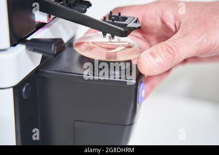 Männlicher Optiker mit moderner optischer Ausrüstung in der Werkstatt Stockfoto