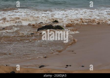 Kleine Wellen Rollen auf einen hellbraunen Sandstrand mit vulkanischem Gestein an der Maalaea Bay in Kihei, Maui, Hawaii, USA Stockfoto