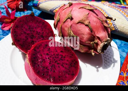 Exotische Früchte genannt Drachenfrucht, Kaktus pitahaya rote Farbe mit ganzen reifen serviert und in Scheiben geschnitten gehackt. Einzigartige verschiedene Früchte in indien Asien gekauft Stockfoto