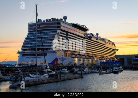 Seattle - 18. Juli 2021- das Schiff Norwegian Encore am Pier 66 an der Küste von Seattle spiegelt die untergehende Sonne wider, während es auf die Segel nach Alaska wartet Stockfoto