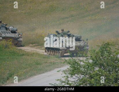 Zwei Panzer der britischen Armee, Warrior FV512, mit mechanisierten Rettungs-Fahrzeugen, die auf der Salisbury Plain Staubwolken hochkicken Stockfoto