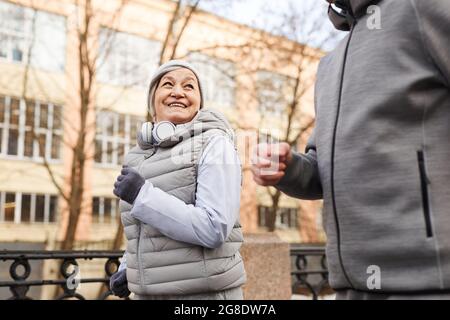 Porträt eines aktiven älteren Ehepaares, das im Winter draußen läuft und fröhlich lächelt, Kopierfläche Stockfoto