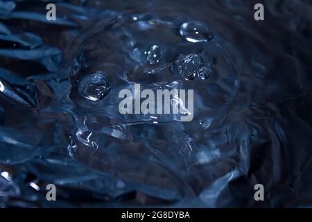 Fallende Wassertropfen bildeten ein Interessantes rundes, lustiges Smiley-Gesicht auf der Wasseroberfläche Stockfoto