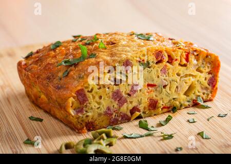 Gesalzener Kuchen aus Eiern, Käse, Oliven, Salami, Pilzen und rotem Pfeffer Stockfoto