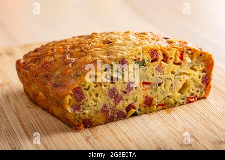 Gesalzener Kuchen aus Eiern, Käse, Oliven, Salami, Pilzen und rotem Pfeffer Stockfoto