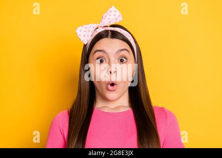Foto von charmanten beeindruckt Schulmädchen tragen rosa T-Shirt großen Augen isoliert gelben Hintergrund Stockfoto