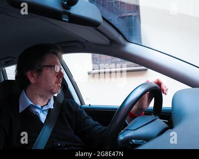 Kaukasischer Mann mittleren Alters, der ein Auto fährt Stockfoto