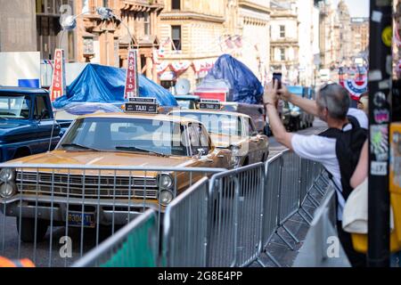 Glasgow, Schottland, Großbritannien. Juli 2021. IM BILD: Auf dem Filmset des neuen Hollywood-Blockbuster-Films von Indiana Jones 5 gehen die Leute herum und schauen sich die Sehenswürdigkeiten im Stadtzentrum an. Sie machen Fotos und Selfies mit ihren Fotohandys. Die Straßen sind mit Sternen und Streifen geschmückt, Flaggen und Ammer, und das Harrison Ford Double wurde auf dem Pferd durch die Straßen von Glasgow reiten gesehen. Quelle: Colin Fisher/Alamy Live News Stockfoto