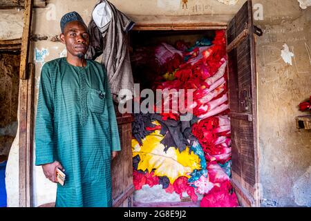 Ladenbesitzer vor seinem Laden voller buntem Leder, Kano, Bundesstaat Kano, Nigeria Stockfoto