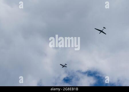 Segelflugzeuge fliegen am Himmel. Extrem aktiver Sport. Wolkiger blauer Himmel mit kleinen motorlosen Flugzeugen. Stockfoto