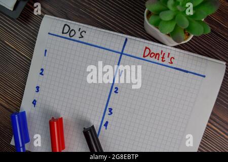 Schreiben Sie auf ein Buch, das auf einem Holztisch isoliert ist. Stockfoto