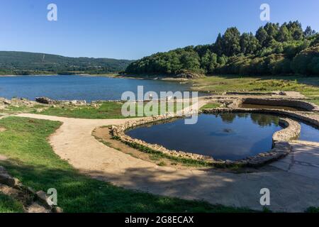 Thermalbad am Stausee in der Landschaft Galiciens bei Tageslicht, OS banos de Bande, Spanien Stockfoto