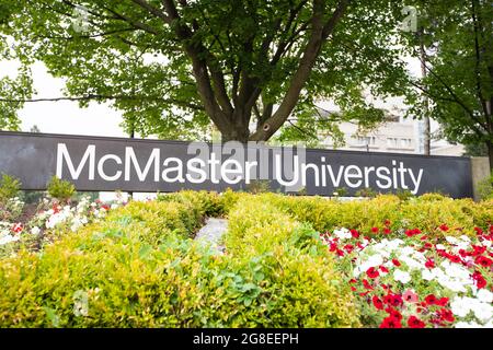 Das Schild der McMaster University wird in einem Blumengarten am Eingang des Campus ausgestellt. Stockfoto