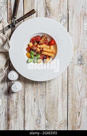 Traditionelle Penne-Pasta mit Tomaten, Gewürzen, Parmesankäse und frischem Basilikum. Gericht der klassischen mediterranen Küche auf einem weißen Teller mit Gabeln auf einem Stockfoto