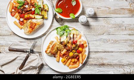 Lebensmittelbanner. Gegrilltes putenfilet, Penne-Pasta mit Tomaten, Gewürzen, Parmesankäse und frischem Basilikum. Tomatensauce. Traditionelle italienische Küche. Stockfoto