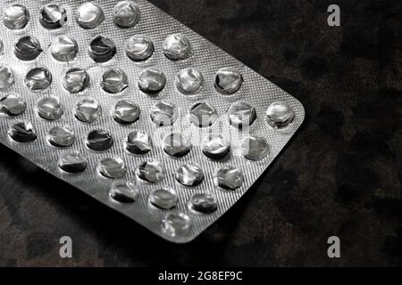 Leere zerknittert Silberverpackung von Pillen auf dem Tisch Nahaufnahme. Stockfoto