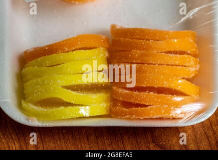 Gelbe und orangefarbene Marmelade in Kunststoffverpackung. Stockfoto