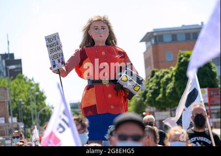 Henstedt Ulzburg, Deutschland. Juli 2021. In der Demonstration wird eine Frauenfigur mit einem Pick-up unter dem Arm und einem Schild mit der Aufschrift „Rechts nichts kontrollieren lassen“ gedrückt. Neun Monate nach einem Zwischenfall bei einer Anti-AfD-Demonstration haben wieder mehrere hundert Menschen aus der linken Szene in Henstedt-Ulzburg (Kreis Segeberg) demonstriert. Am 17.10.2020 hatte ein AfD-Sympathisant Teilnehmer einer Kundgebung gegen eine AfD-Veranstaltung mit seinem Auto getroffen und verletzt. Quelle: Jonas Walzberg/dpa/Alamy Live News Stockfoto