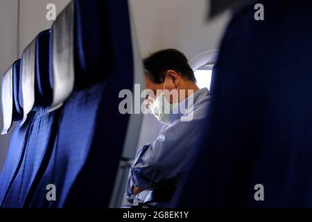 Tokio, Japan. Juli 2021. Ein Passagier, der eine Gesichtsmaske trug, sah, wie er im ANA-Flugzeug (All Nippon Airways) schlief. (Bild: © James MATSMOoto/SOPA Images via ZUMA Press Wire) Stockfoto