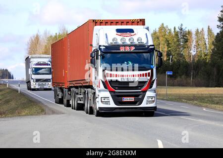 Schwere Lkw von Iveco Stralis und Volvo ziehen an einem Frühlingstag Güteranhänger entlang der Autobahn. Jokioinen, Finnland. 29. April 2021. Stockfoto